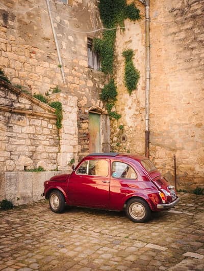 Classic Red Fiat 500 in a Rustic Italian Courtyard