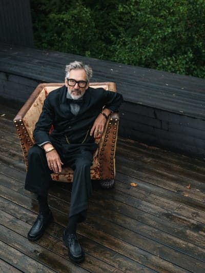 Sophisticated Man in Vintage Armchair on Wet Deck