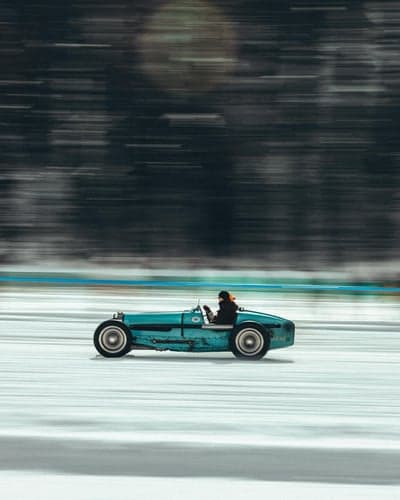 Vintage Teal Race Car Speeding on Ice