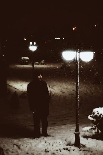 Solitary Man in a Snowy Night Park